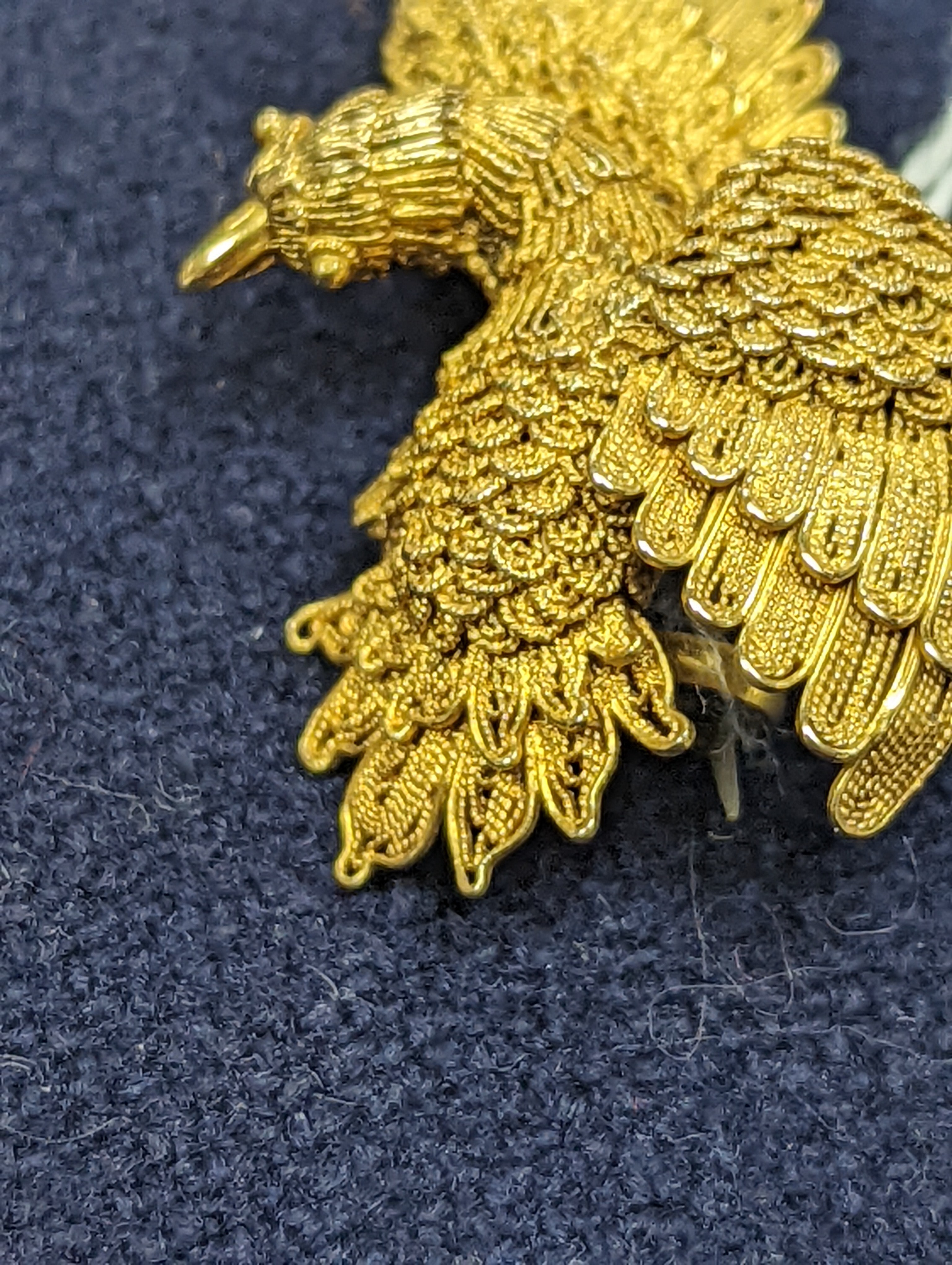 A Chinese filigree yellow metal eagle brooch, stamped 'WS 20 (with character marks)', 36mm, gross 6.5 grams.